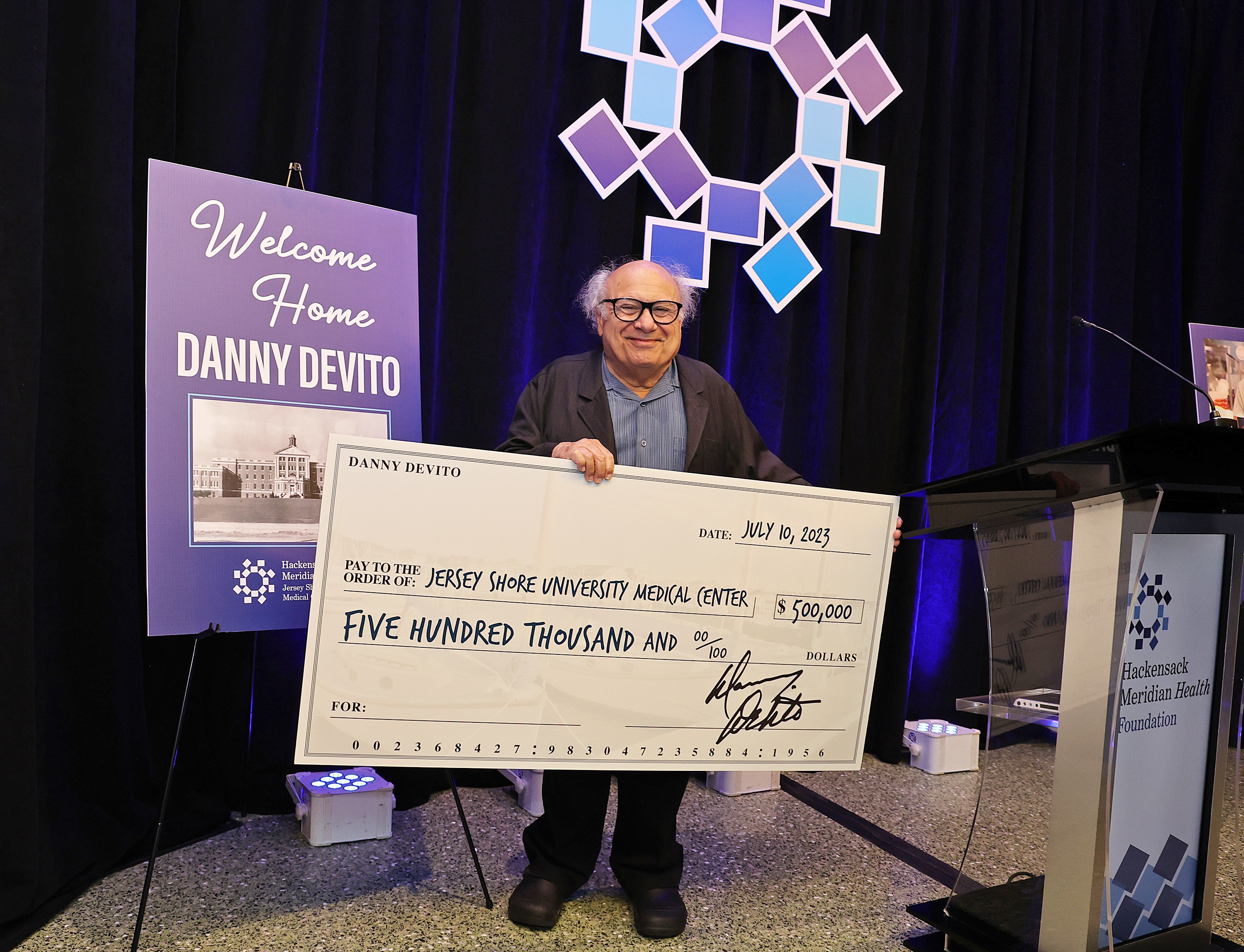 Danny DeVito with a check for Jersey Shore University Medical Center