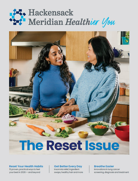 Two women it kitchen cutting vegetables on cutting board