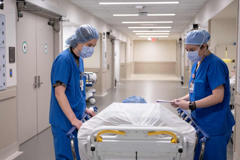 Two doctors with a patient in a transport bed, in the hallway, on the way to an organ transplant procedure.