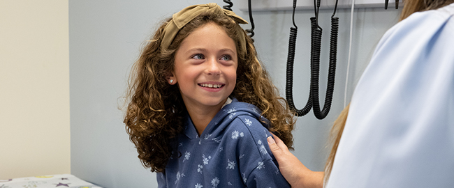 7-year-old Colette smiling at the doctor's office.
