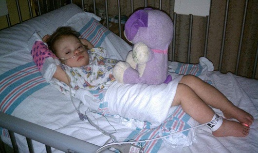 Ally Kistler as a toddler laying in the hospital bed after admission