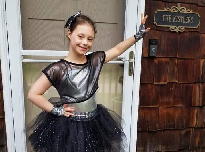 Ally Kistler standing outside her house, in a dance pose for a dance recital 