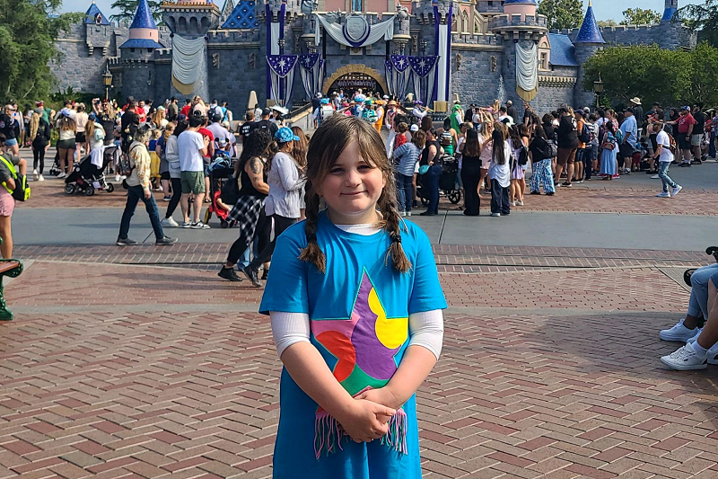 6-year-old Gitty Rubin standing smiling while at a Disney park.