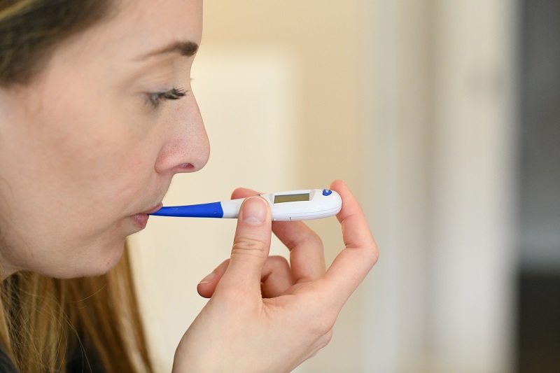 young woman taking temperature