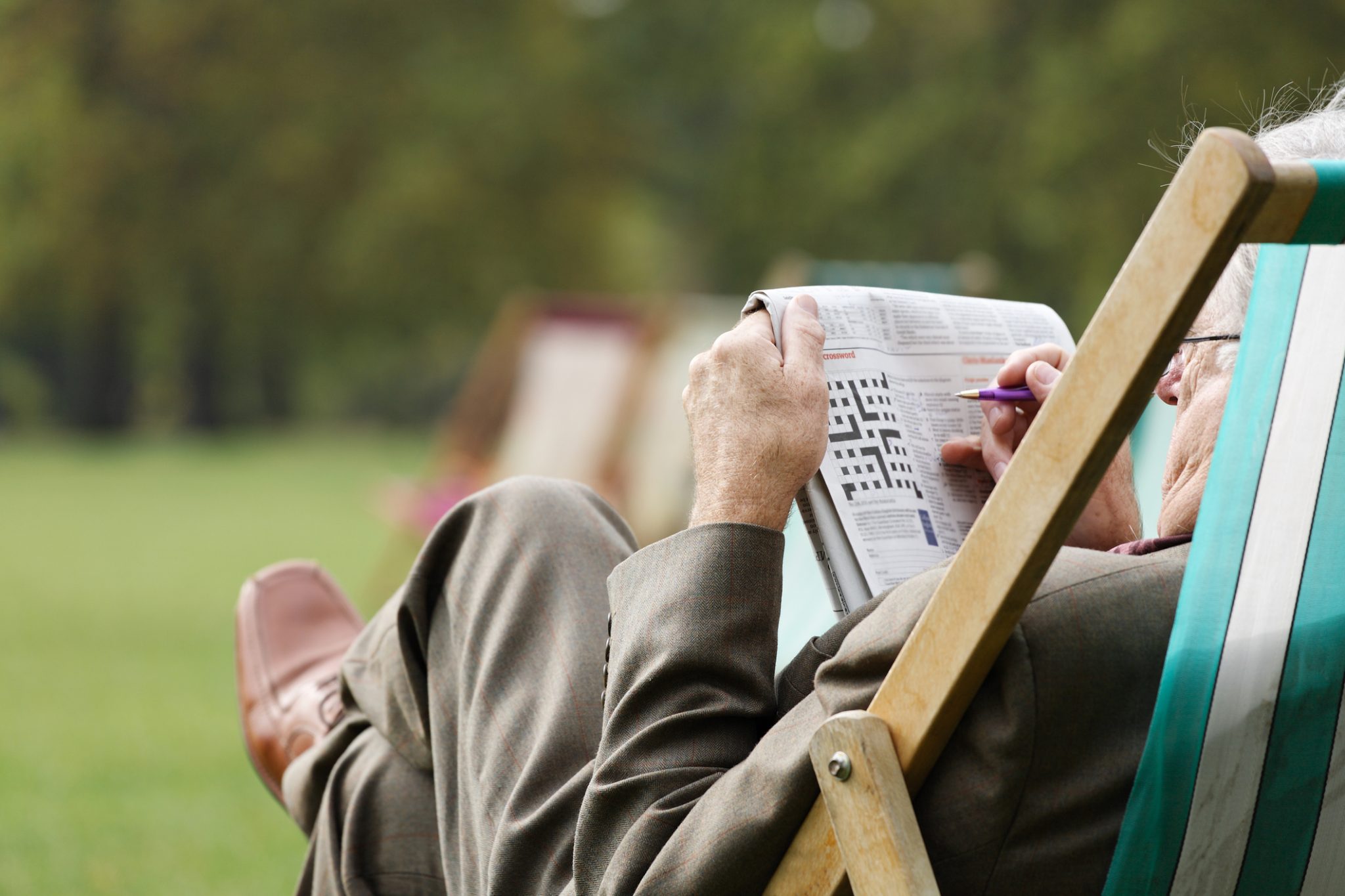 Man completing crossword puzzle