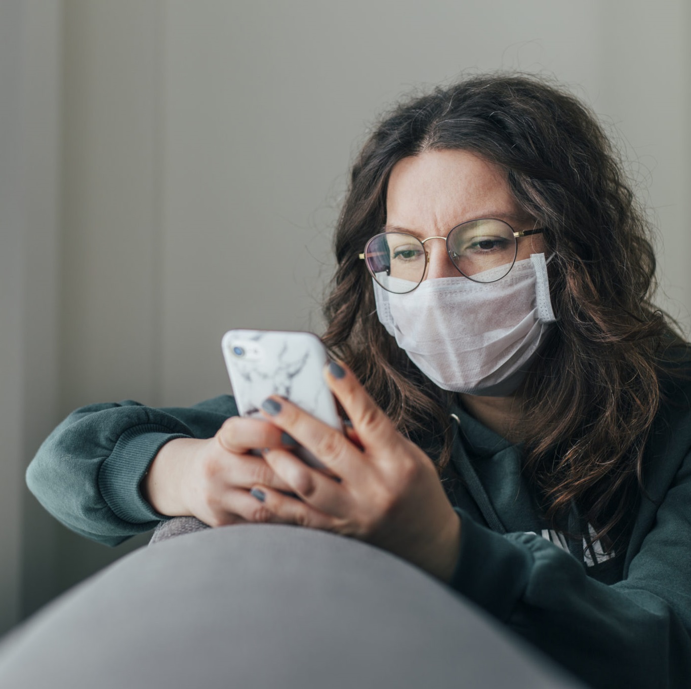 Masked woman looking at phone