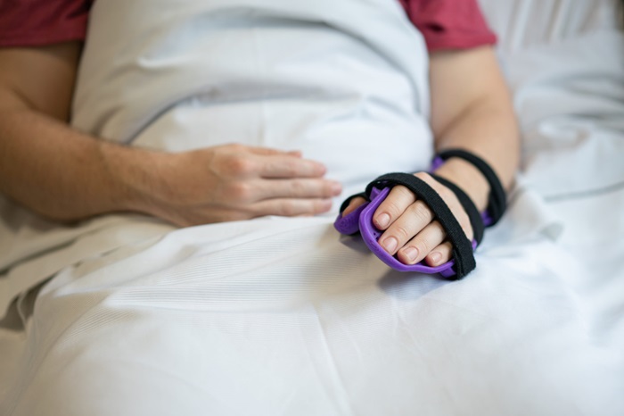 Person in bed with hand brace