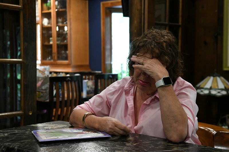 Woman rests her head in her hands. She is stressed and managing anxiety or a panic attack.