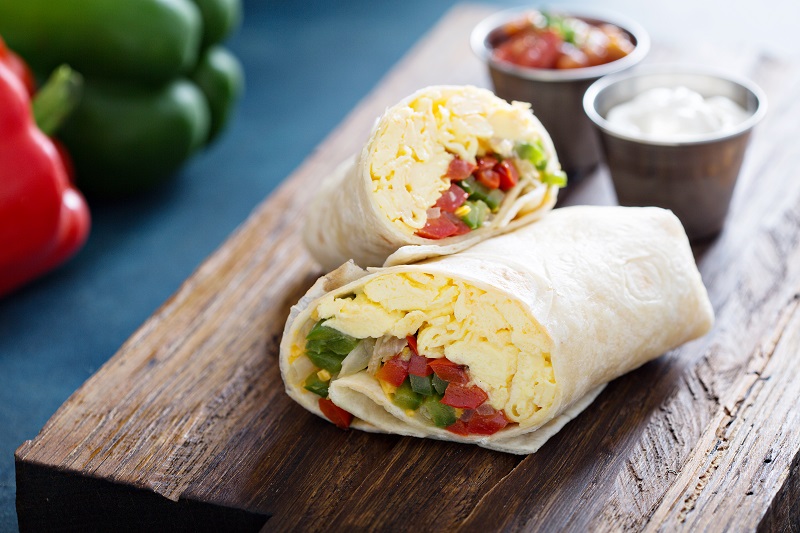 Breakfast burrito with eggs and salsa.