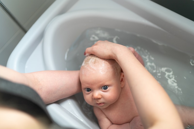 washing a small infant in a bath