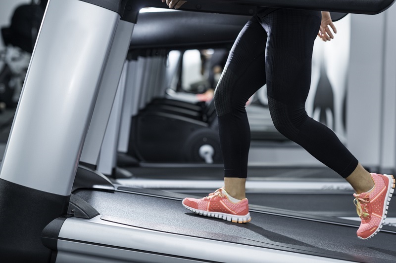 Woman using a treadmill at an incline.