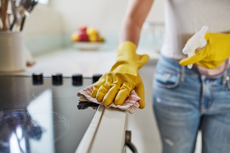 Cropped shot of a woman cleaning a kitchen counter at home.