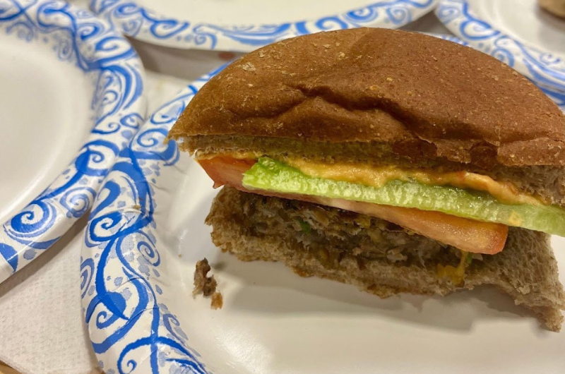 A black bean and farro vegetable burger is shown on a paper plate.