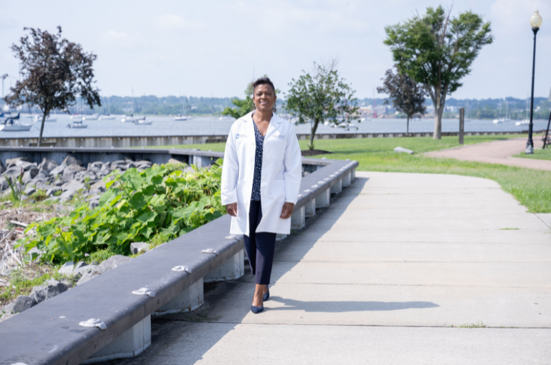 Karen Young, M.D., of Perth Amboy, stands outside with a body of water behind her.