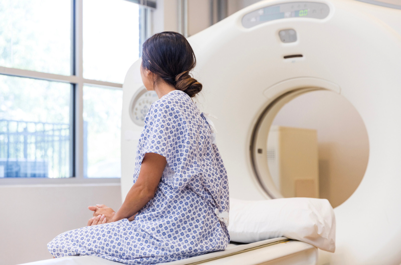 Female physician listens to the lungs of a female senior patient with a stethoscope.