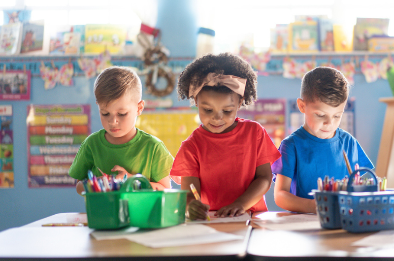 Three preschoolers actively learning and growing in a nurturing daycare environment.