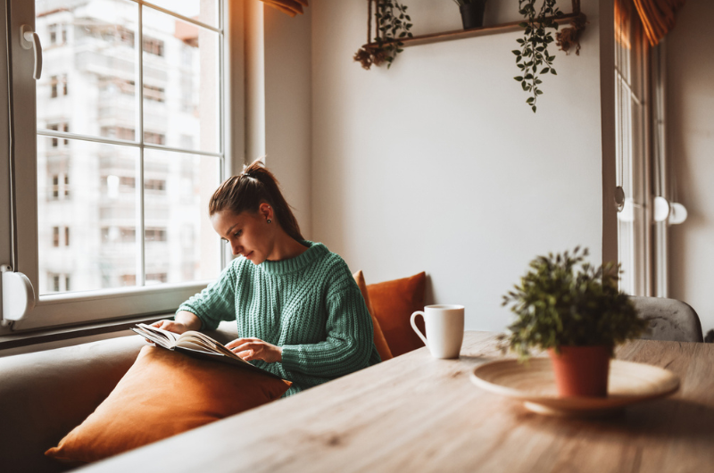After improving her home’s air quality, a woman looks through a photo album comfortably in her kitchen.
