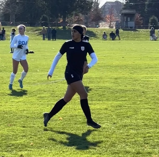 Kelis Guzman running on soccer field.