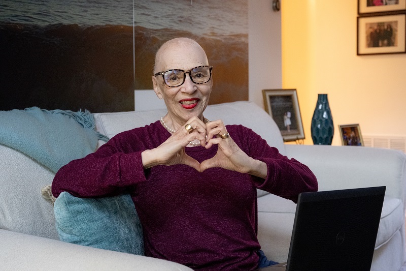 Rose C. smiling and holding her hands in a heart shape.