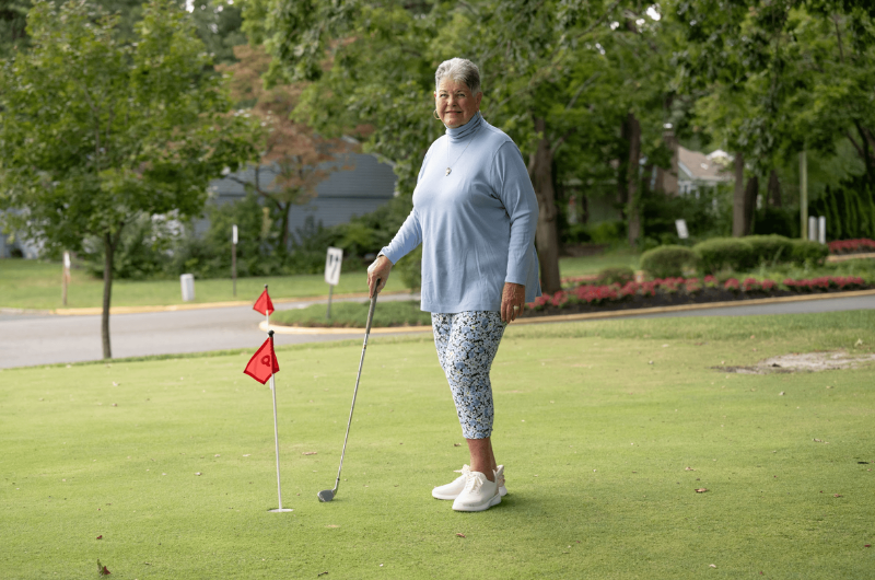 Kathryn Moore, 80, of Manchester, New Jersey, holds her golf club while standing on a putting green.