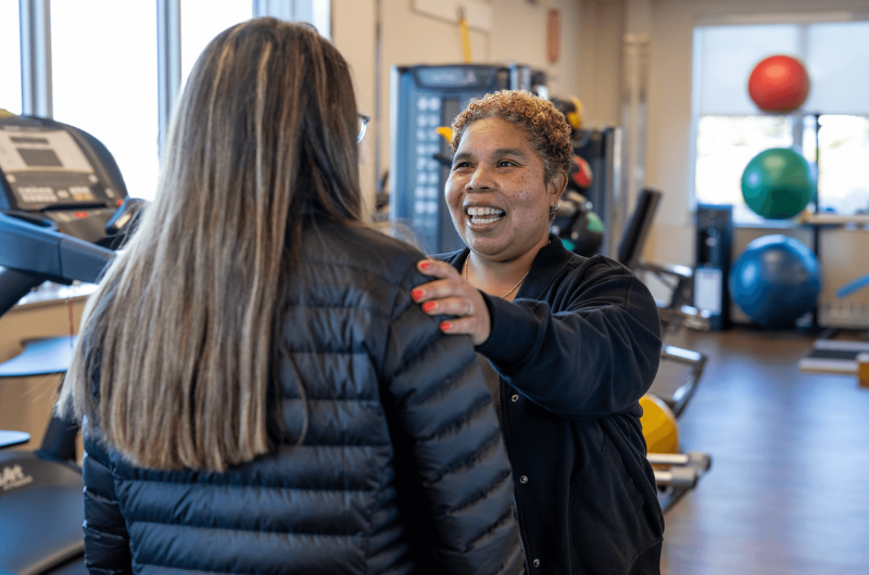 Aretha Watson, Ph.D., smiles and puts her hand on a woman’s shoulder.