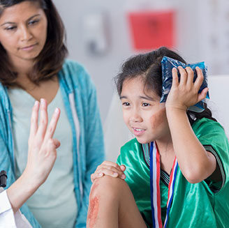 Kid with scrapes on legs and icepack on face