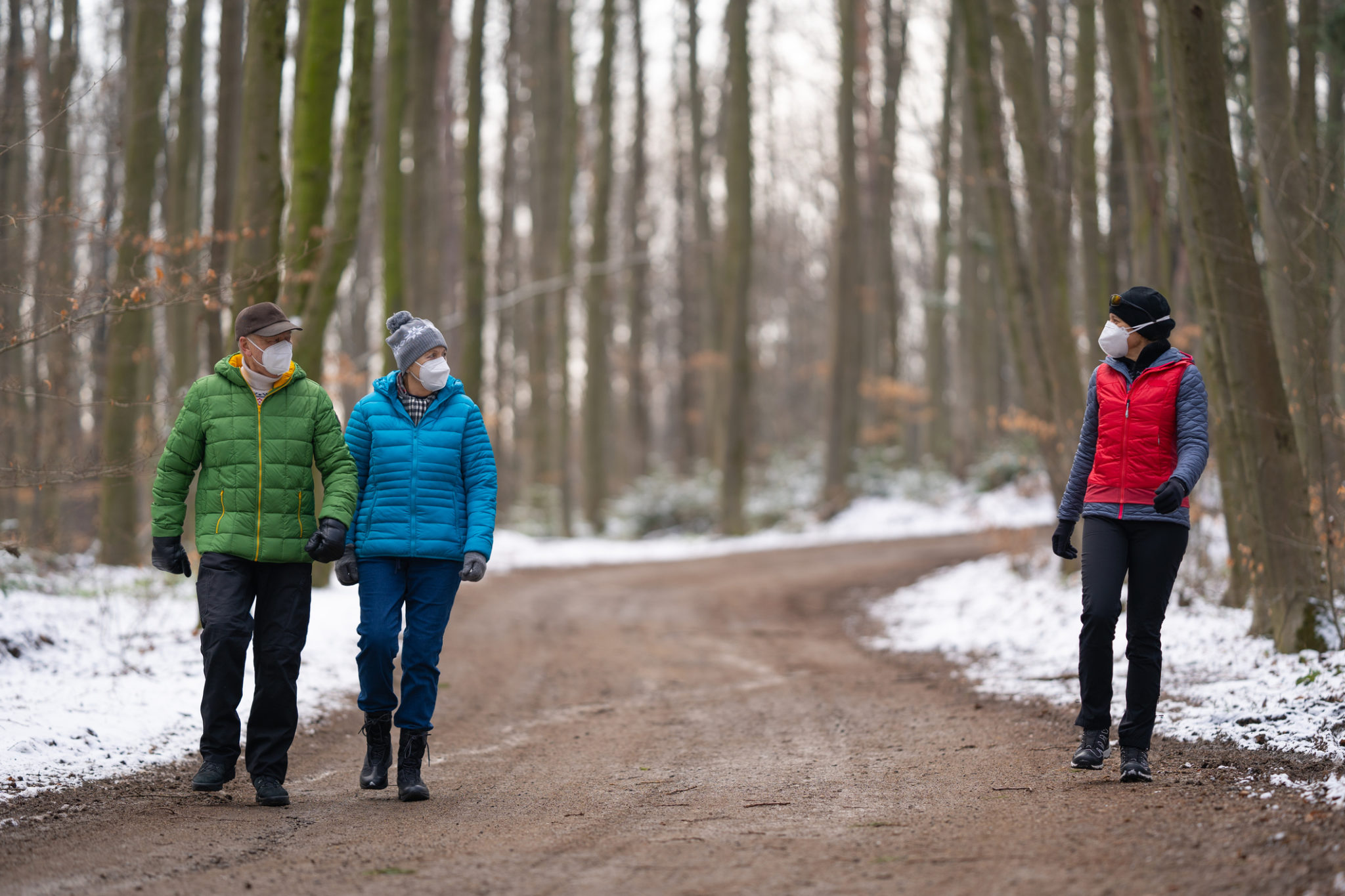 Three people outdoors hiking with masks