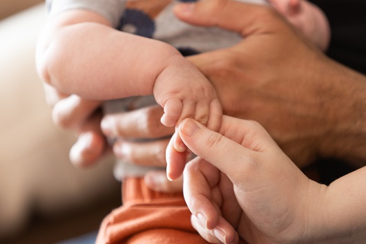 A close up of baby Benny's hand being held by his mother's.