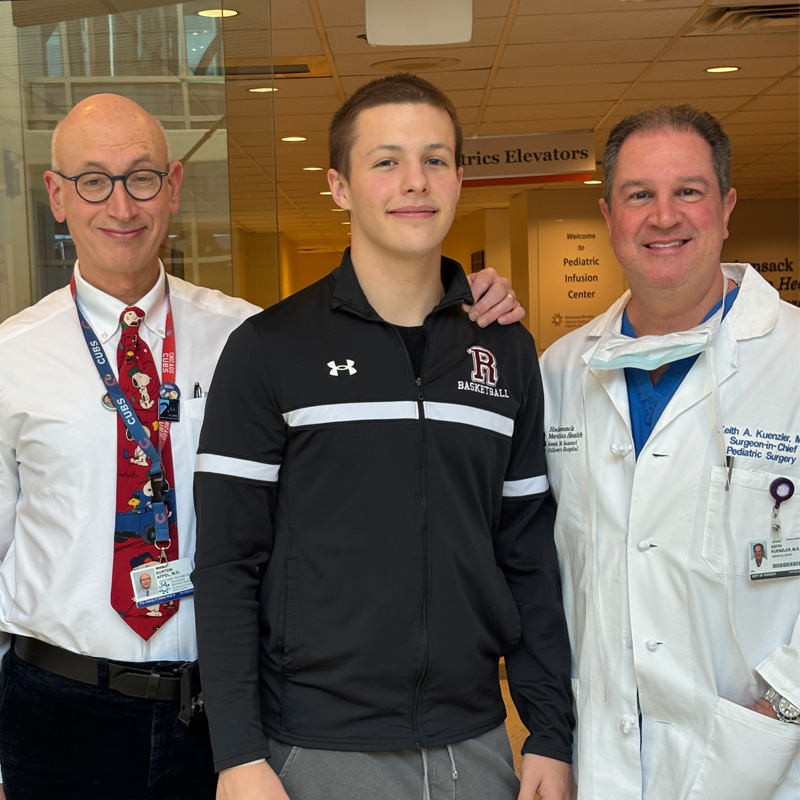 Teen boy standing between 2 doctors