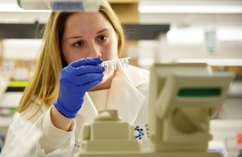 Blonde woman in the lab with blue glove