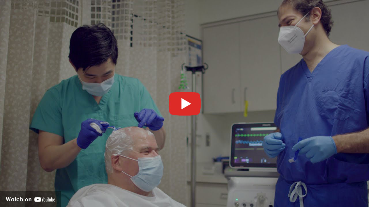 Clinicians preparing patient for tremor treatment