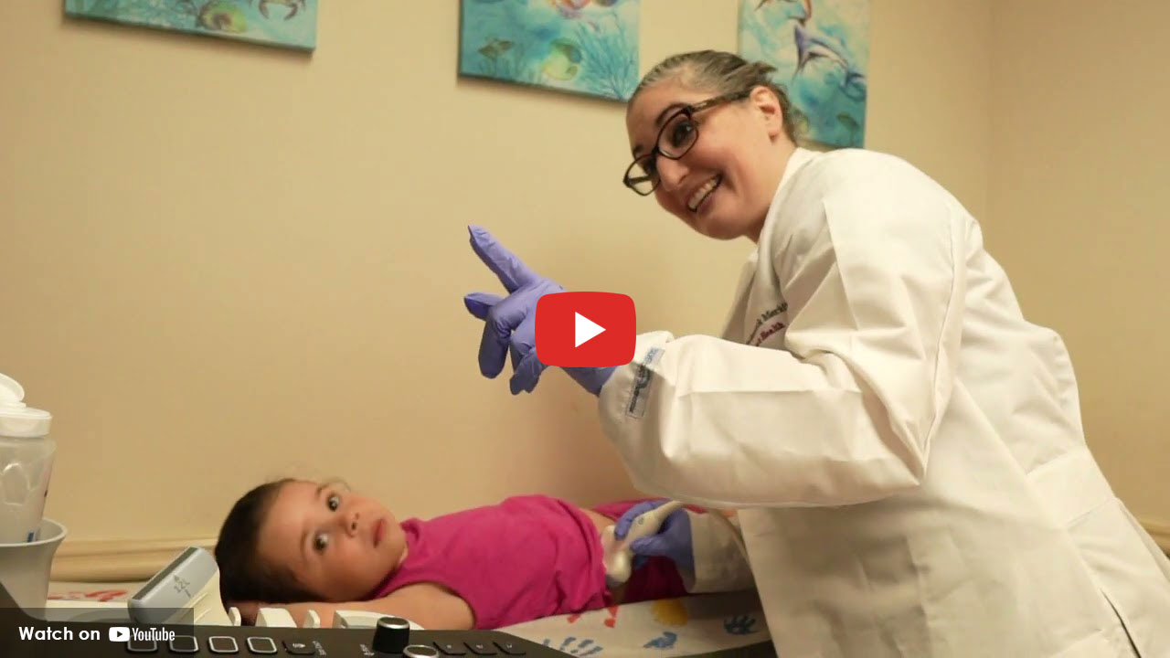 Healthcare provider smiling while examining a young child during a medical visit