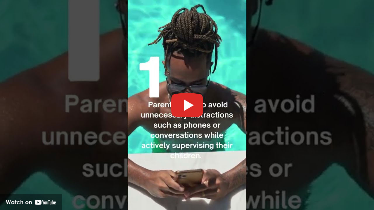 person in pool looking down at phone