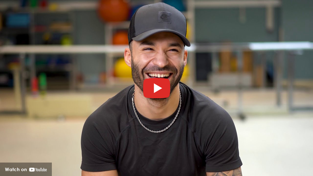 Man in hat smiling in rehab setting