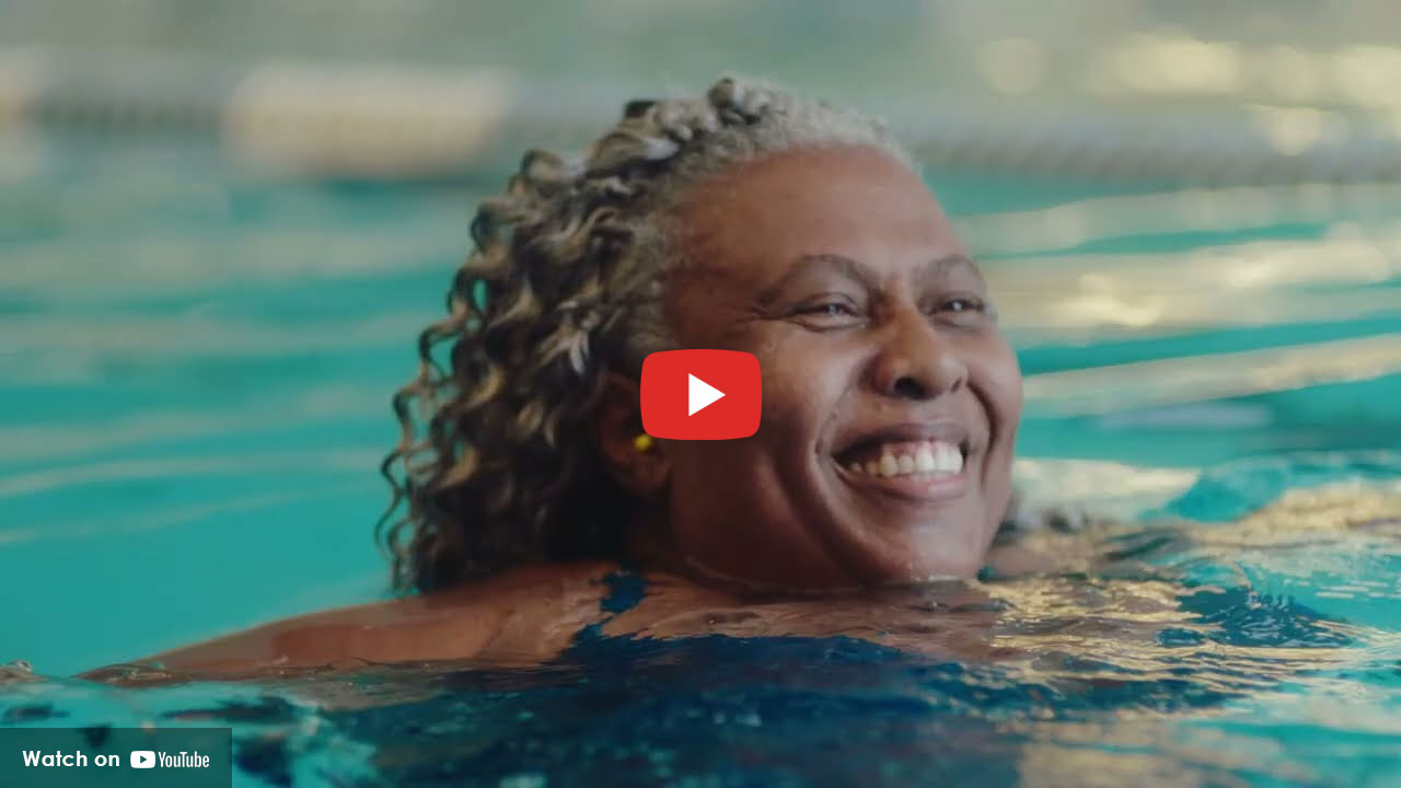 Smiling woman swimming in an indoor pool.