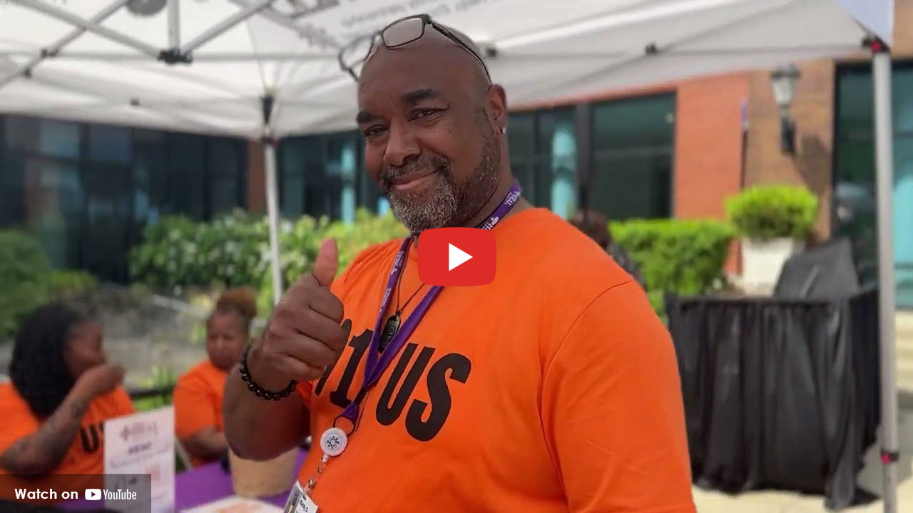 African American man giving a thumbs up wearing an orange shirt