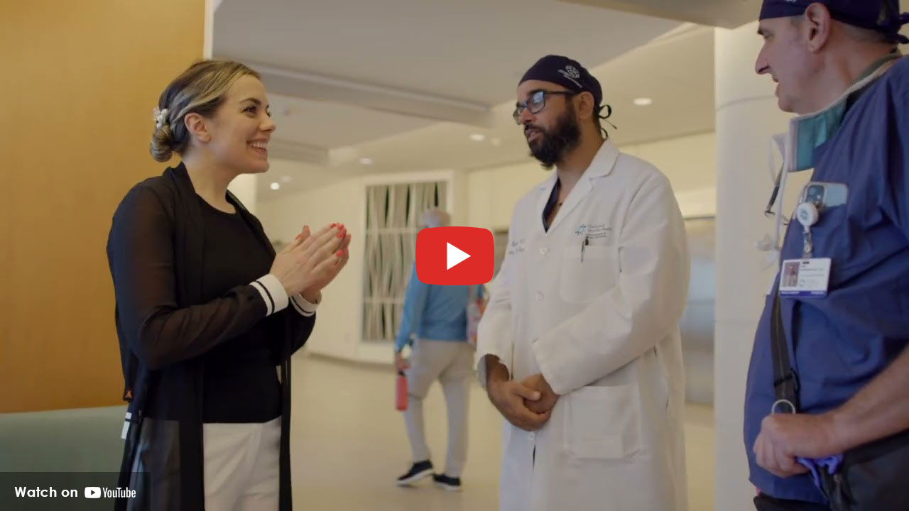 Patient speaking with doctors in a hospital hallway